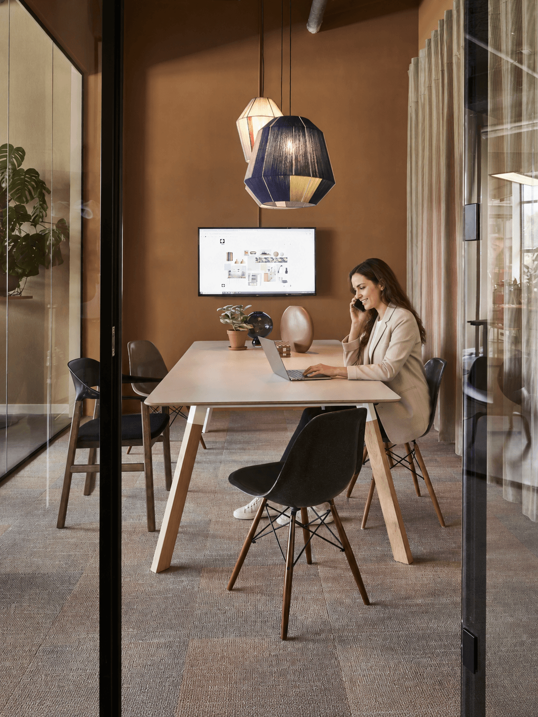 Medewerker werkt aan een kleine tafel in een glazen werkcabine