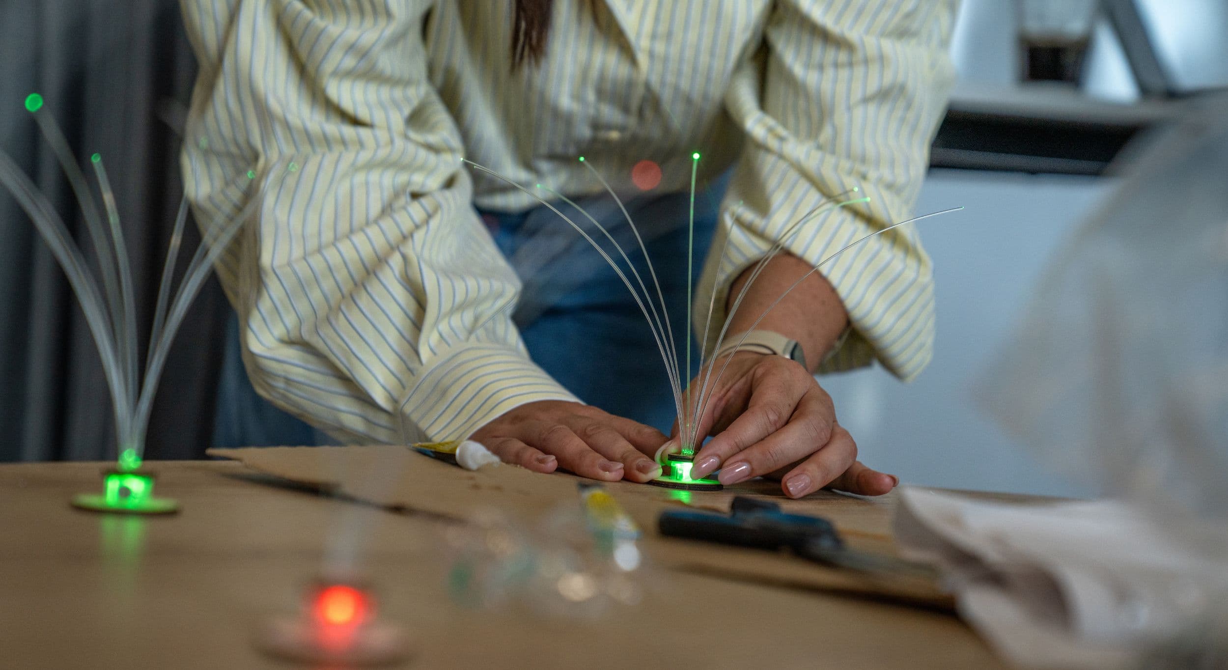 Handen plaatsen een verlicht fiberlamp op een maquette