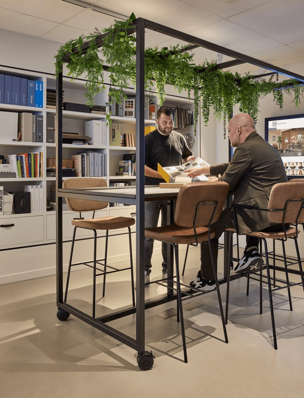 Interieuradviseur bespreekt materiaal- en kleurstalen met een klant in de showroom.