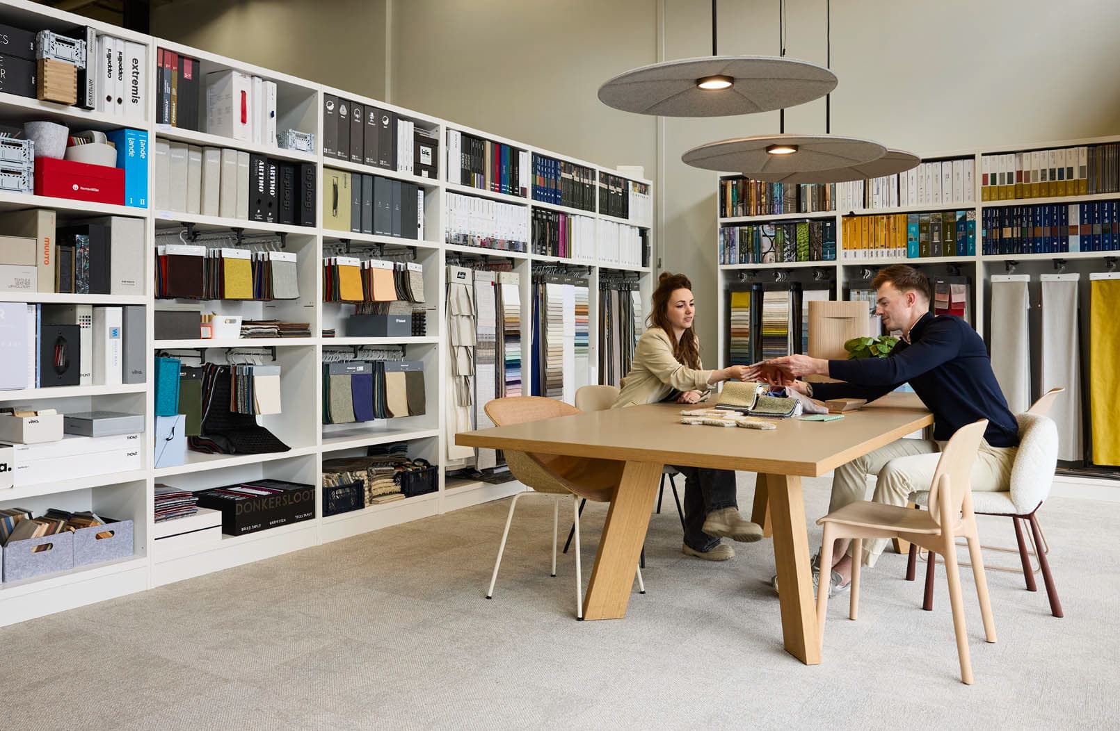 Medewerkers overleggen in een materialenbibliotheek met kleur- en materiaalstalen